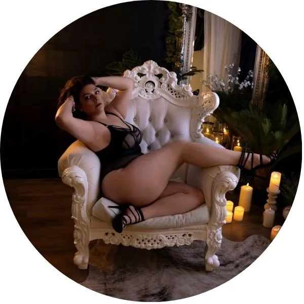 Lady posing in french white roccoc chair during photo shoot
